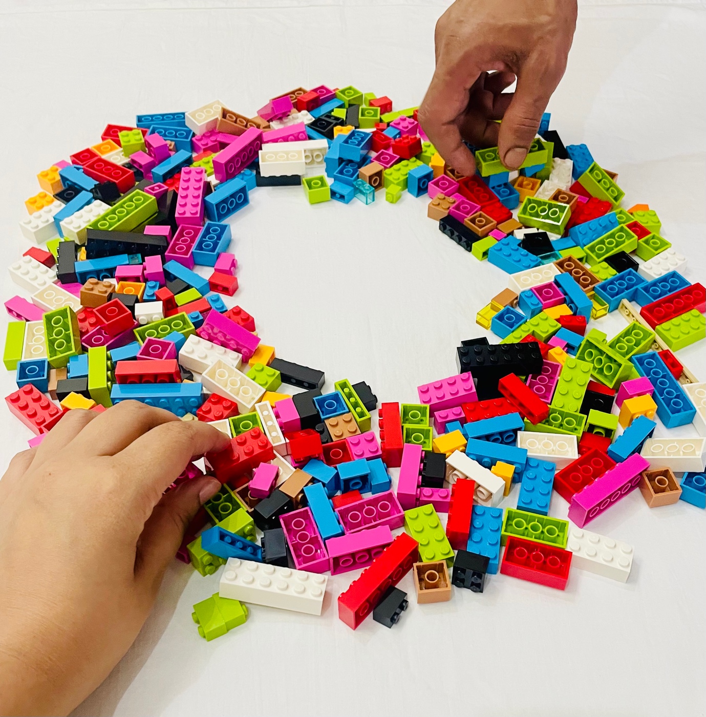 Hands selecting colourful LEGO bricks for a workshop activity